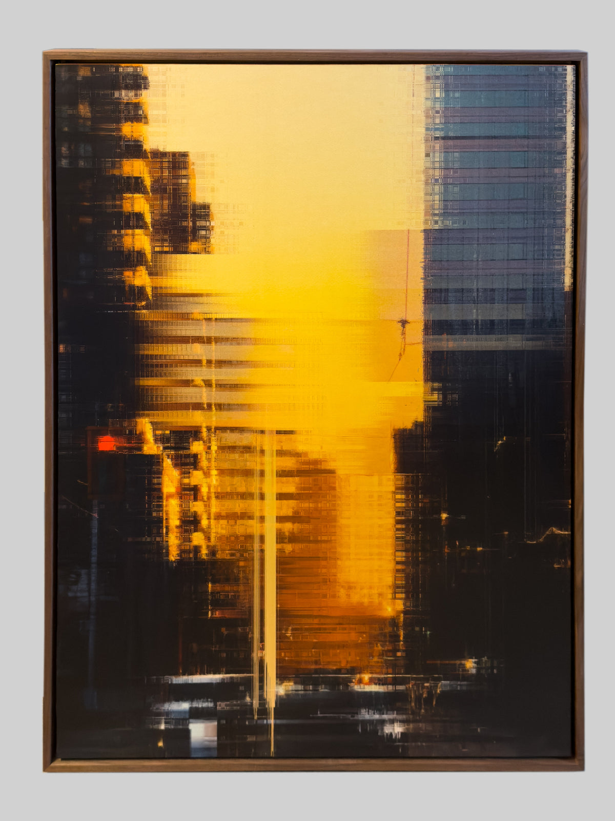 An abstract framed artwork featuring a bold yellow and black composition with horizontal streaks and architectural-like forms, presented against a light gray background.
