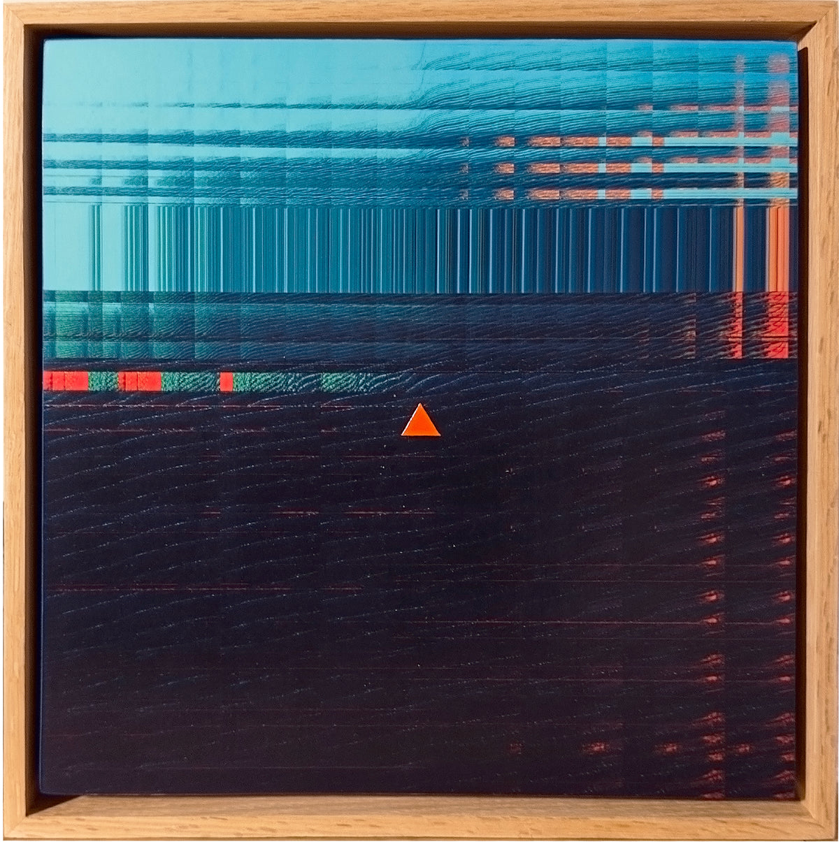 Abstract framed artwork featuring a teal and dark navy textured composition with horizontal line patterns, small red accents, and a small orange triangle near the center, enclosed in a light wood frame.