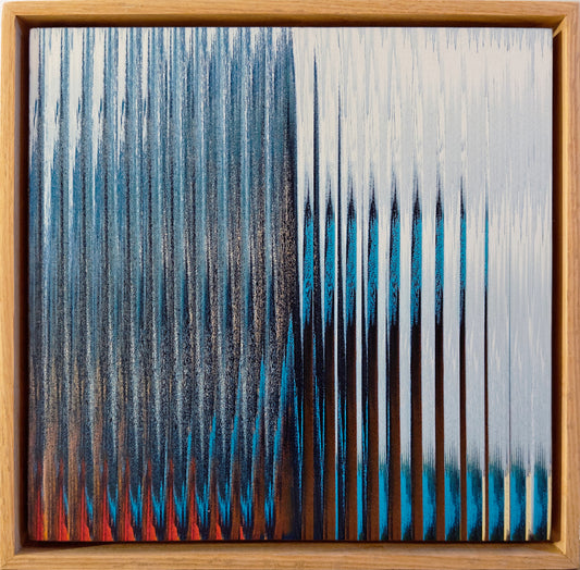 A framed abstract artwork featuring vertical textured brushstrokes in blue, black, white, and red, enclosed in a natural wood frame.