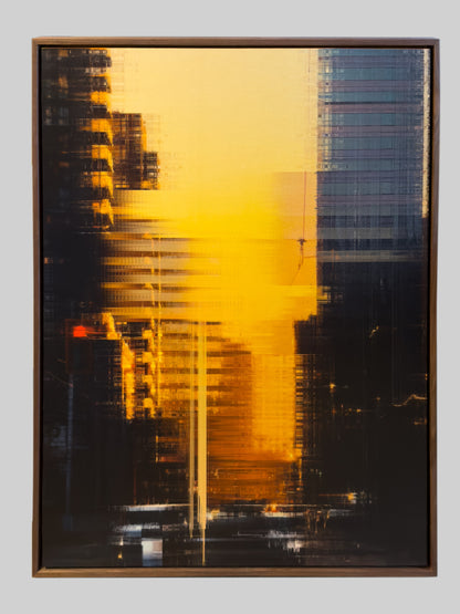 An abstract framed artwork featuring a bold yellow and black composition with horizontal streaks and architectural-like forms, presented against a light gray background.