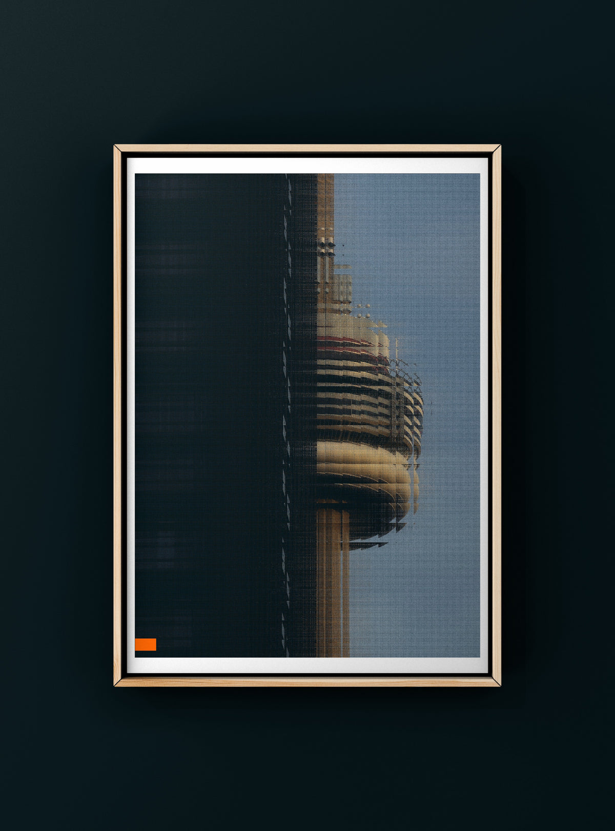 A framed art print featuring a close-up architectural image of the CN tower glitched, displayed on a dark wall. The print has a white mat and a thin gold frame.